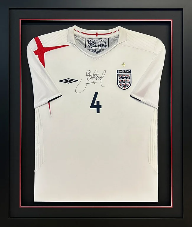 Gold package: signed Gerrard England shirt floated under a raised black double mount with a red inner line, in a black frame