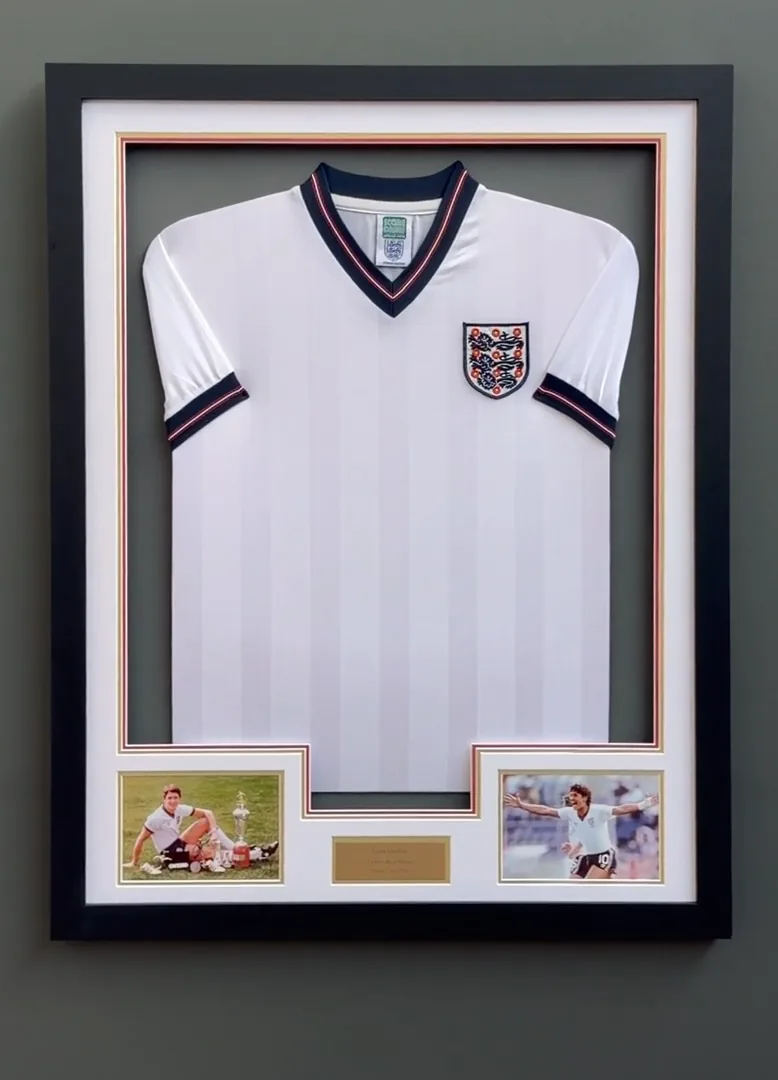 Framed England football shirt on a green wall