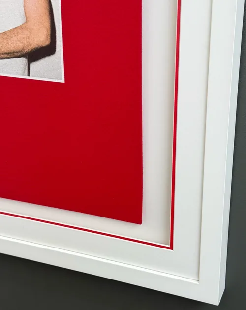 The bottom corner of the frame, the shirt sitting inside the red-lined mount