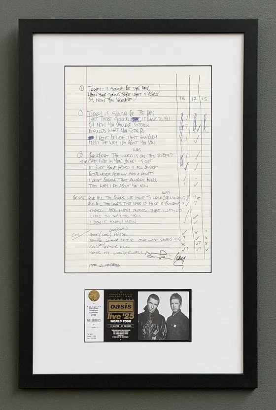 A handwritten Wonderwall lyric sheet framed above an Oasis Live '25 ticket