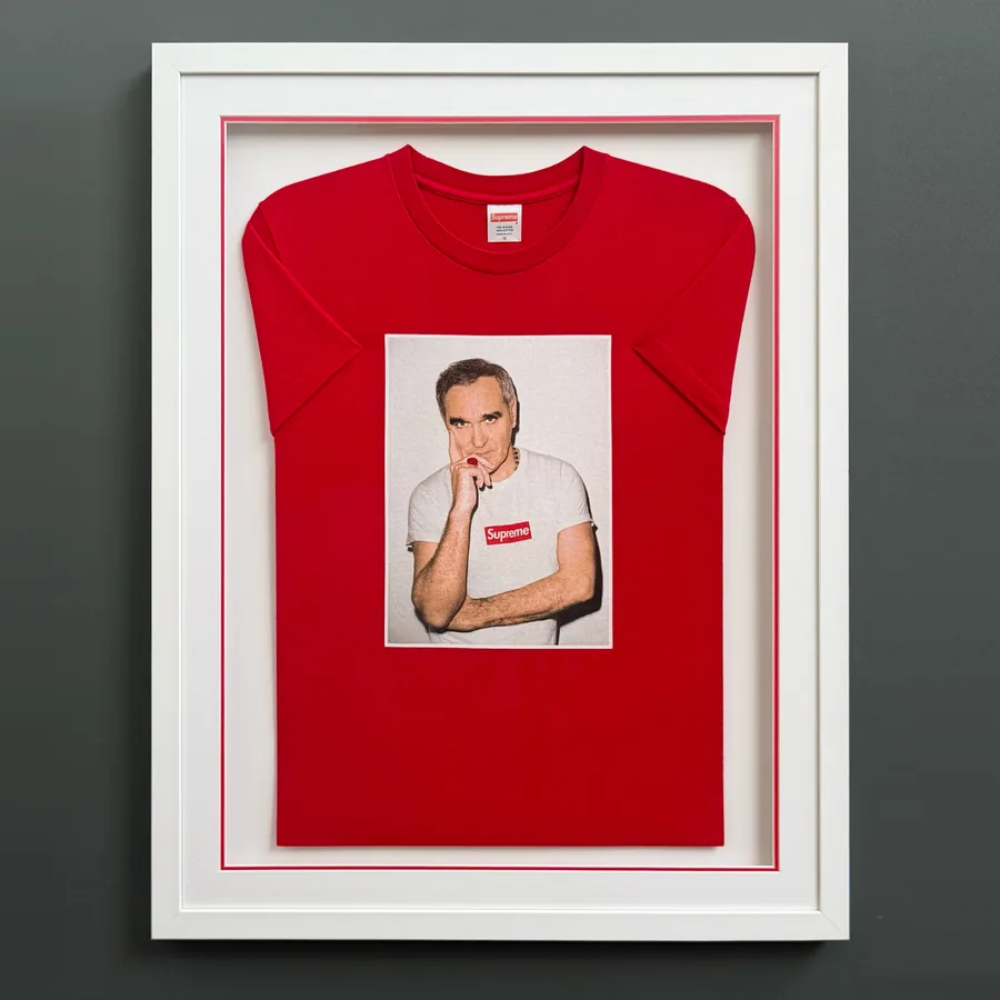 A red Supreme T-shirt with a Morrissey photo print in a white frame, with a white mount and a fine red inner line