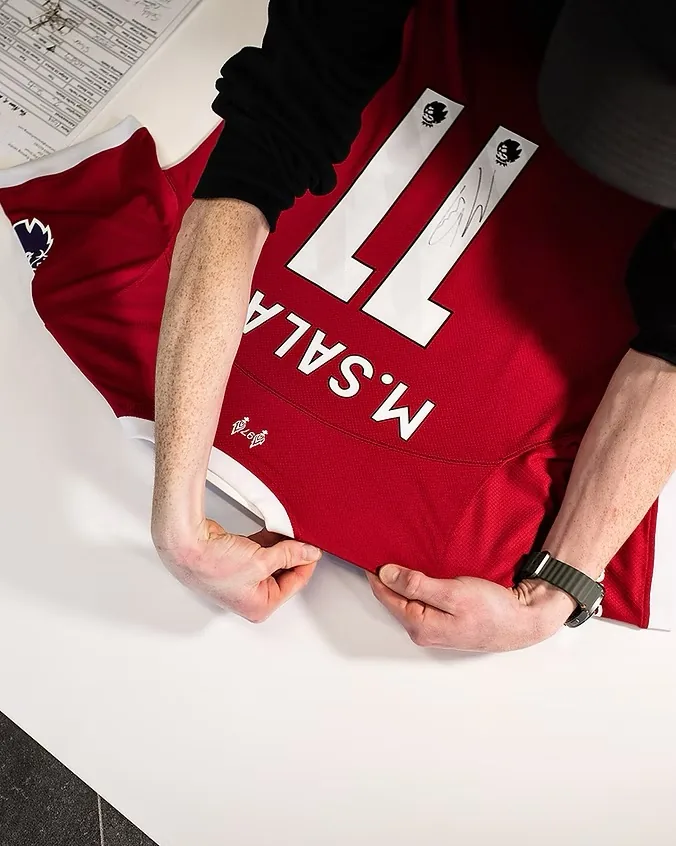 Signed shirt being prepared for framing