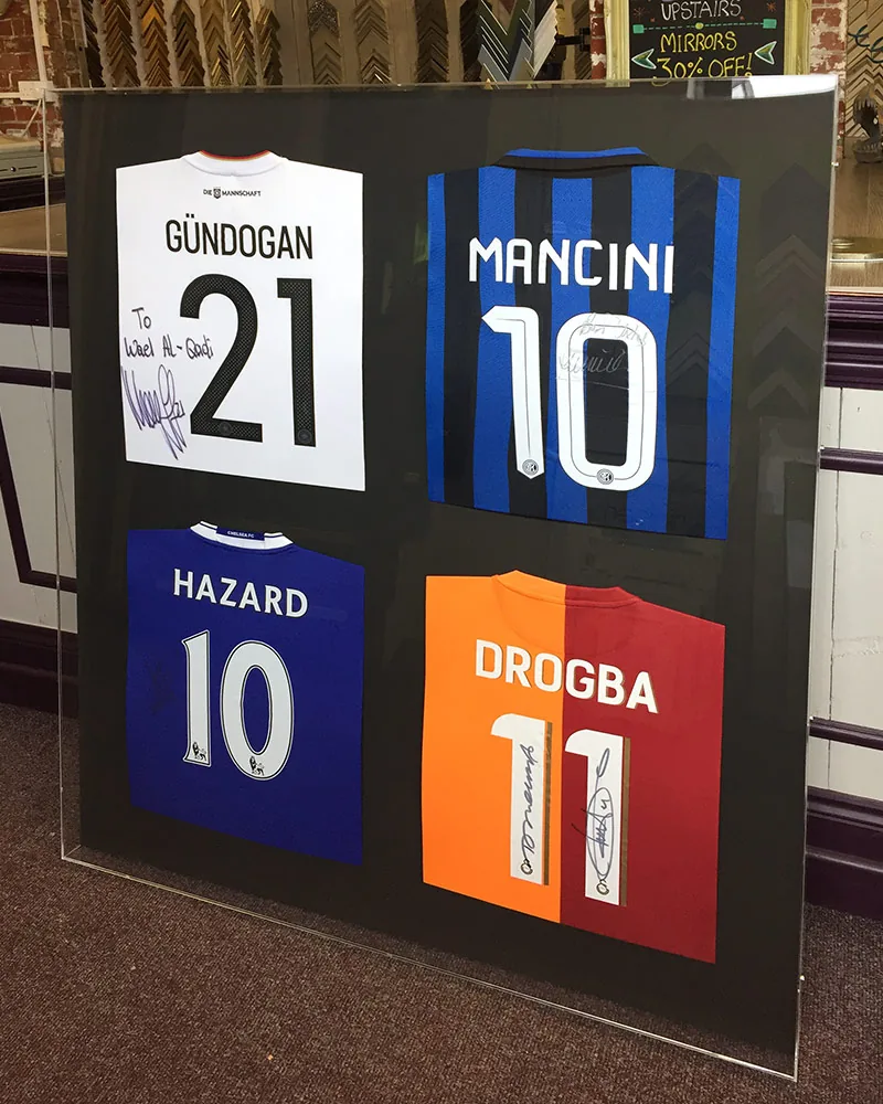 Four signed football shirts presented together in a bespoke Perspex box frame
