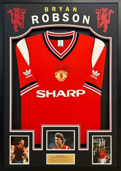 Framed Bryan Robson Manchester United football shirt with match images and engraved plaque